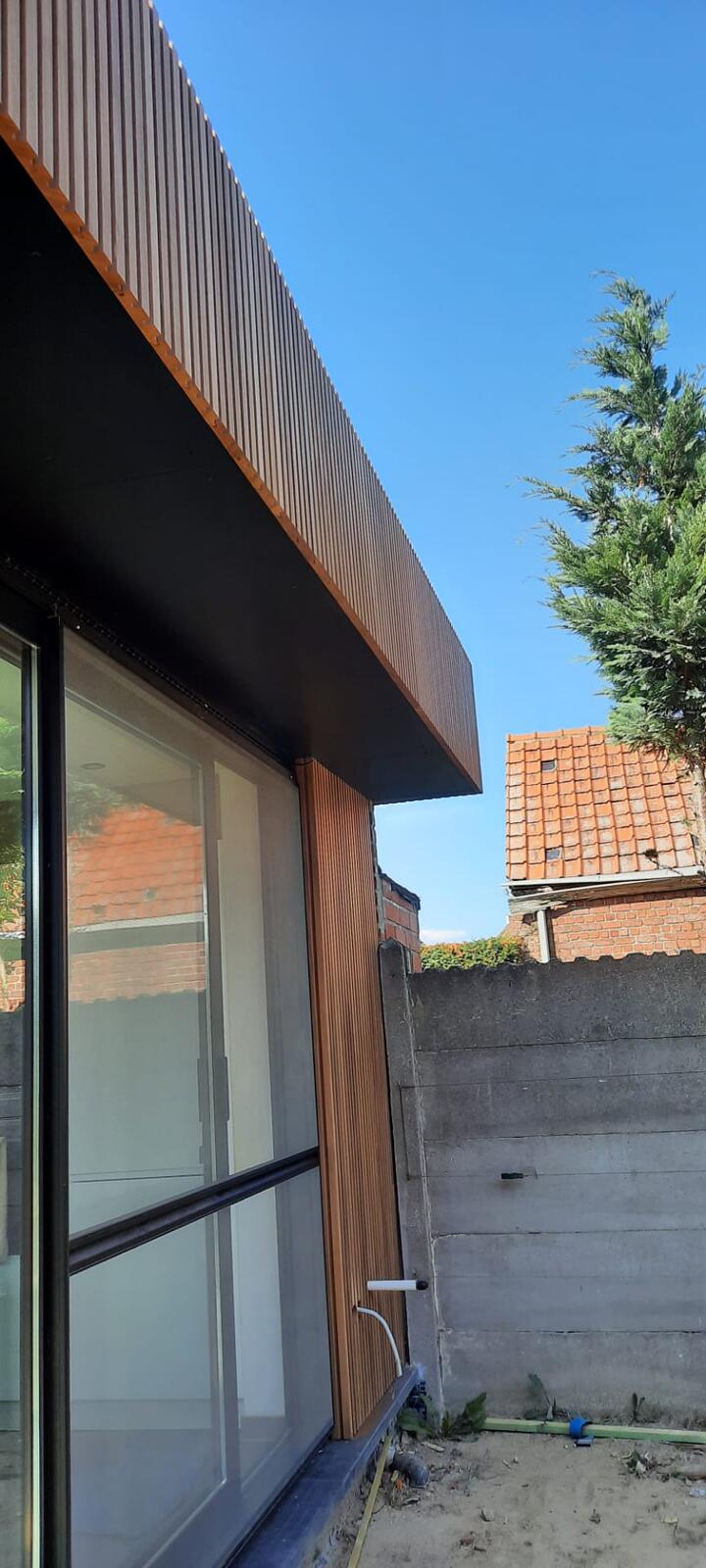 Afwerking uitbouw in thermowood ayous, oversteek in cedral board met bijhorende schroeven
